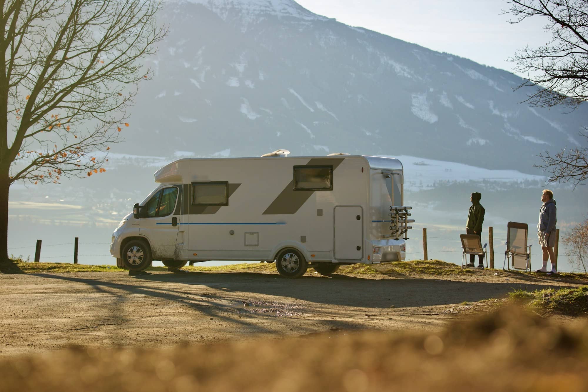 Twee mensen bij een camper aan een meer